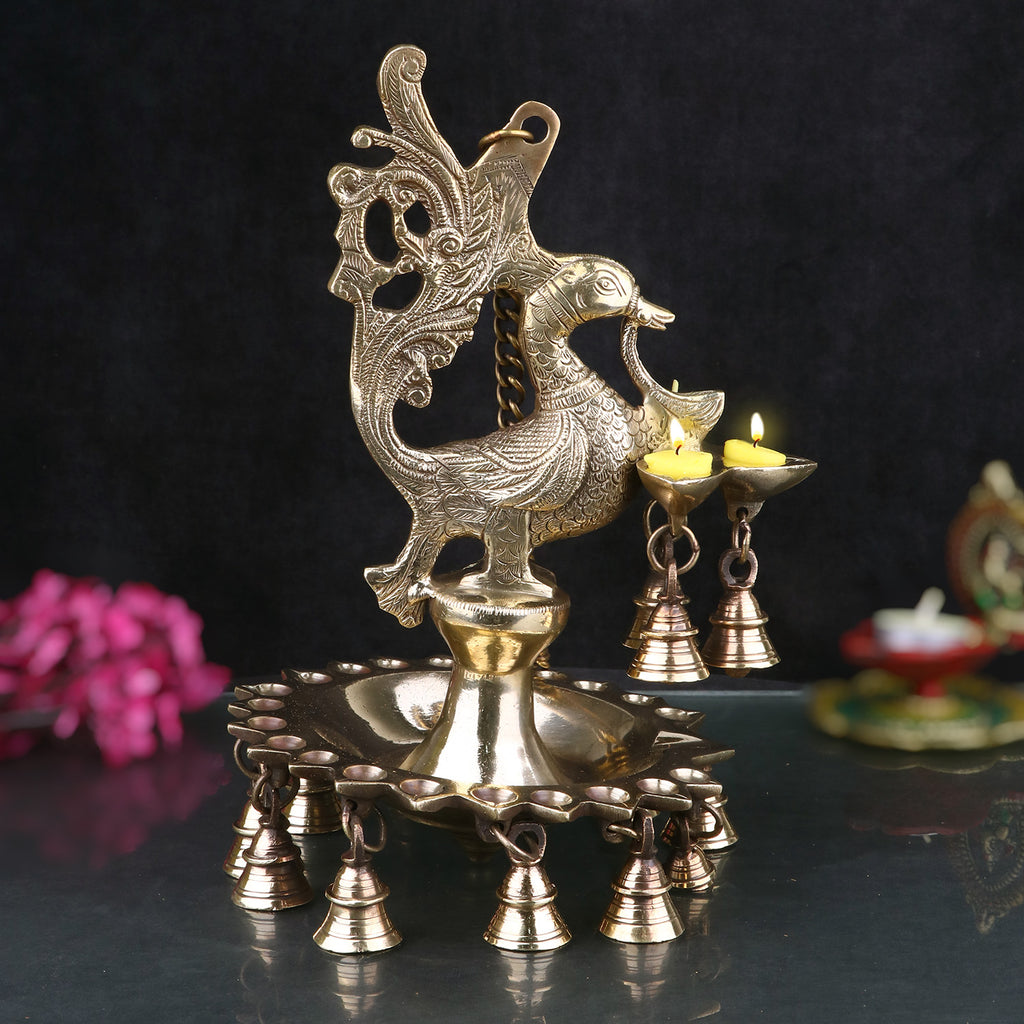 A stunning Brass Peacock Diya Hanging with Bells, featuring a graceful peacock design with a shiny brass finish.  India’s Largest Pooja Accessories Brand – www.satvikstore.in