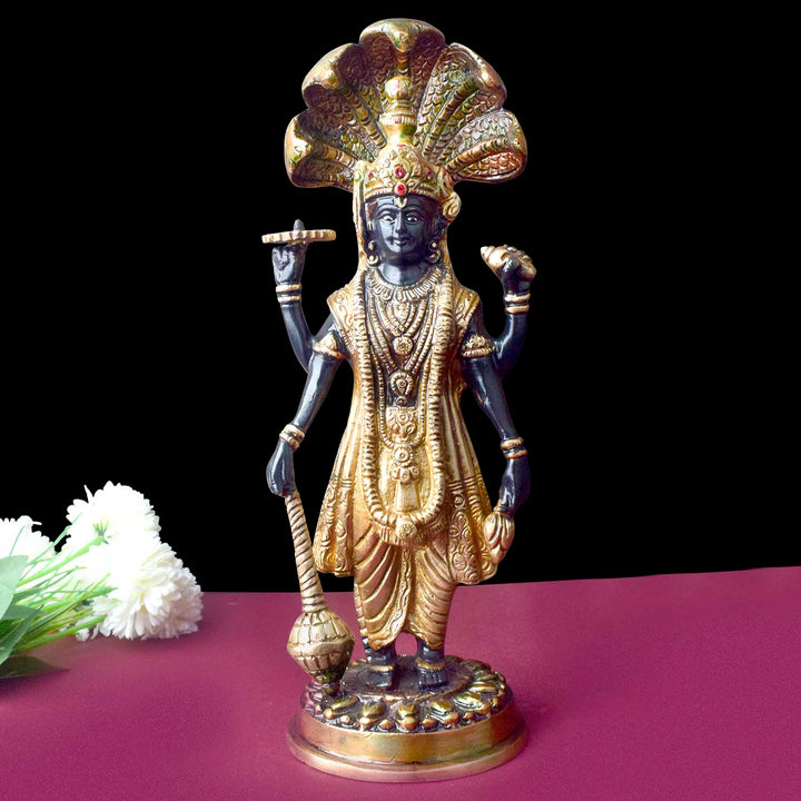  This elegant brass statue of Lord Vishnu seated on the mighty Seshnag is a powerful symbol of divine protection, balance, and cosmic order. The intricate craftsmanship beautifully depicts Lord Vishnu in his serene and majestic form, with the multi-headed Seshnag providing a protective canopy. 