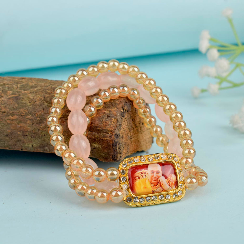 Golden Clear & Pink Triple Layer Guruji Swaroop Bracelet featuring sparkling golden clear beads with soft pink middle layer and Jai Guruji Swaroop – perfect for spiritual wear, meditation, and gifting. India’s Largest Pooja Accessories Brand – www.satvikstore.in