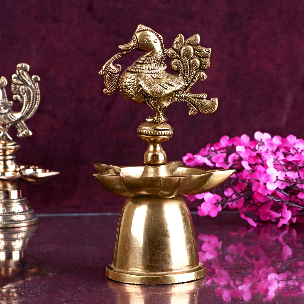 A beautifully designed Peacock Brass Diya featuring intricate detailing of peacock feathers and a polished brass finish.  India’s Largest Pooja Accessories Brand – www.satvikstore.in