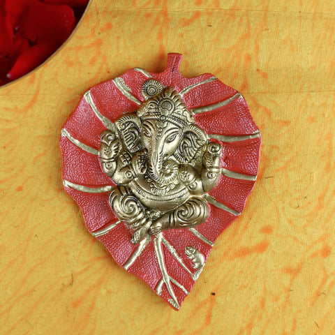 Red leaf-shaped wall hanging featuring a beautifully detailed idol of Lord Ganesh, perfect for spiritual and festive home decor. India’s Largest Pooja Accessories Brand – www.satvikstore.in